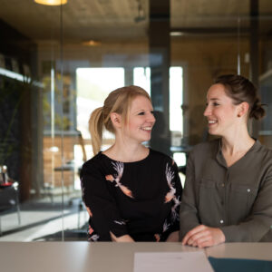 Lisa Hoffmann und Freya Willicks lachen sich an - Titelbild des Blogbeitrags "weit&weiter gestaltet Lehre an Hochschulen – jetzt auch mit einem Blog"