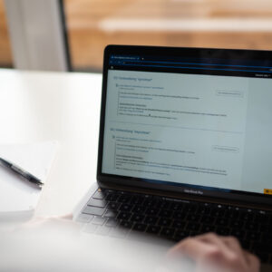 am Laptop arbeitende Person - Titelbild des Blogbeitrags "Arbeitsaufträge zielführend gestalten – so werden Ihre Lernenden aktiv"
